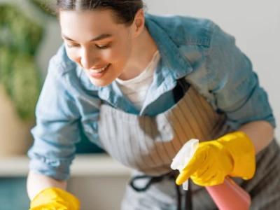 A woman wears gloves while cleaning.