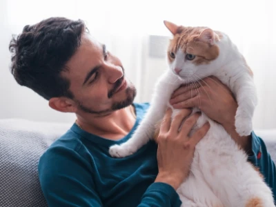 A young man holding a cat.