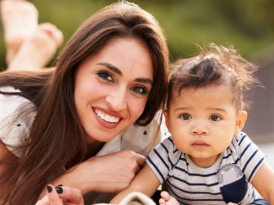 Woman with her son sits together in the grass.
