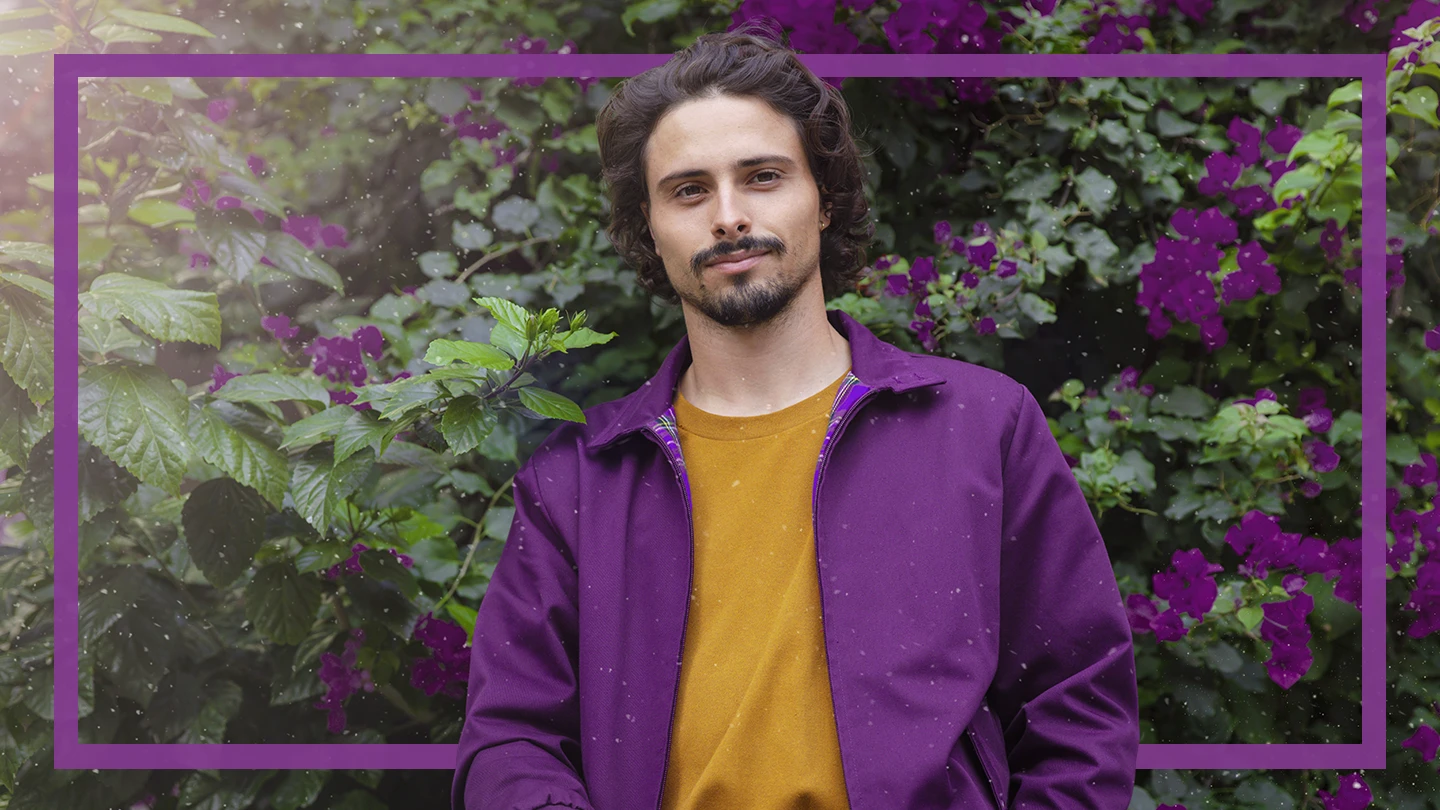A woman confidently standing outside in front of some trees.