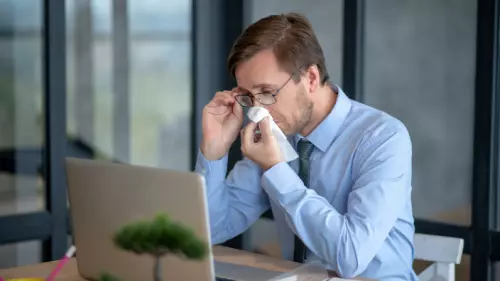Businessman trying to clear a blocked and stuffy nose